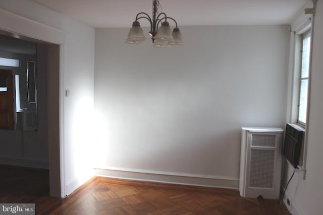 unfurnished dining area featuring dark parquet flooring, a wealth of natural light, and a chandelier