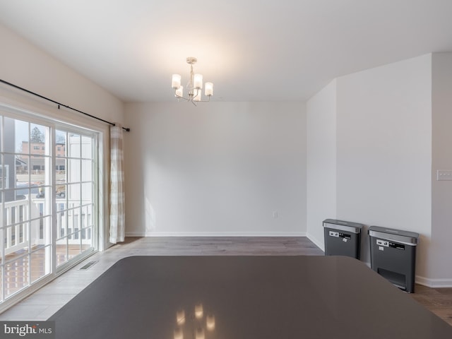 unfurnished dining area with hardwood / wood-style floors and a chandelier