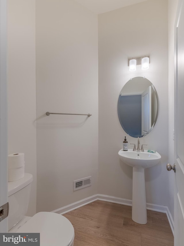 bathroom with wood-type flooring and toilet