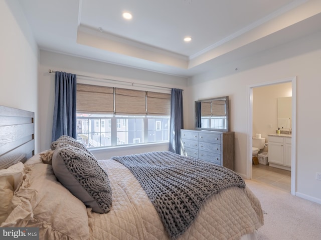 bedroom featuring ornamental molding, ensuite bathroom, a raised ceiling, and light carpet