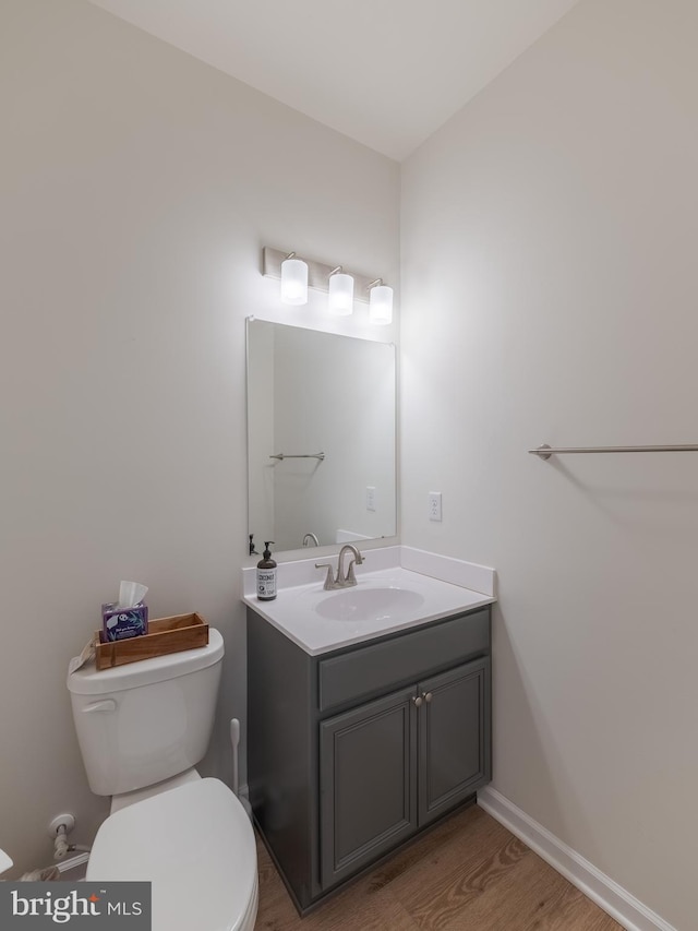 bathroom featuring vanity, wood-type flooring, and toilet