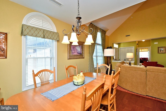 dining area featuring lofted ceiling, dark hardwood / wood-style floors, and a notable chandelier