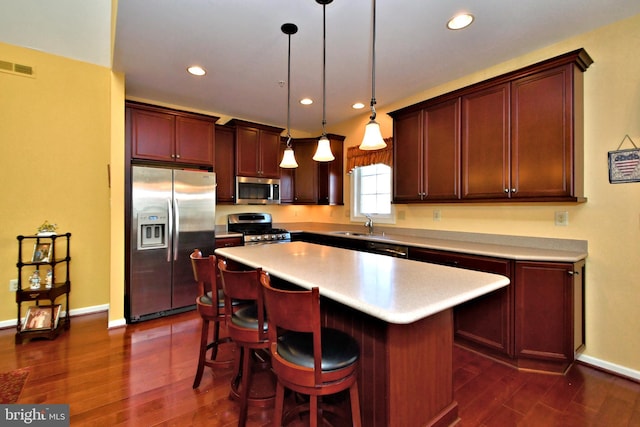 kitchen featuring sink, a center island, hanging light fixtures, dark hardwood / wood-style floors, and stainless steel appliances