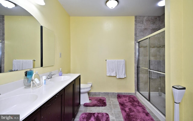 bathroom featuring an enclosed shower, vanity, tile patterned flooring, and toilet