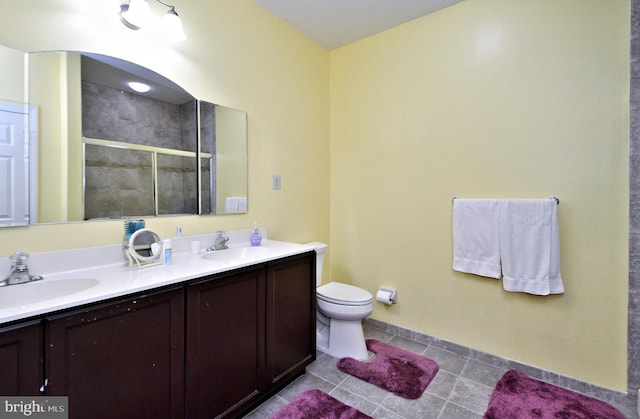 bathroom with walk in shower, tile patterned floors, vanity, and toilet