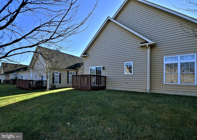 back of property featuring a yard, cooling unit, and a deck