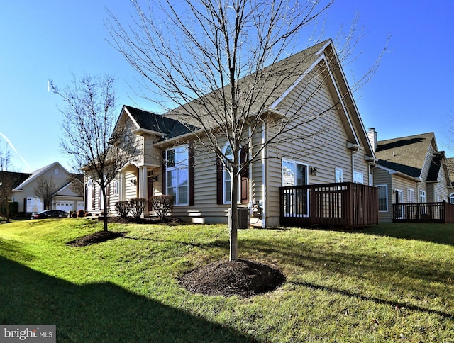 view of front of house featuring a wooden deck, a garage, and a front yard