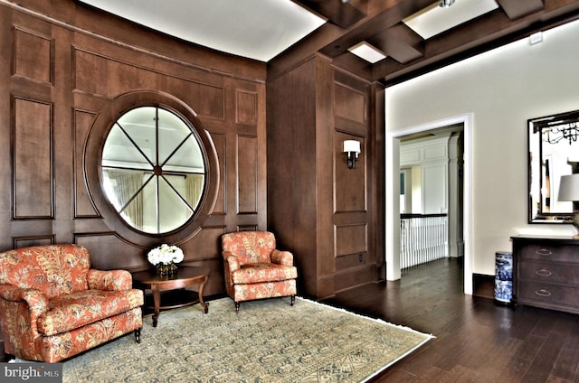 sitting room featuring beam ceiling, coffered ceiling, dark hardwood / wood-style floors, and wooden walls