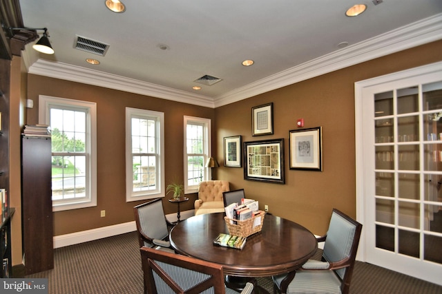 dining room featuring ornamental molding and dark carpet