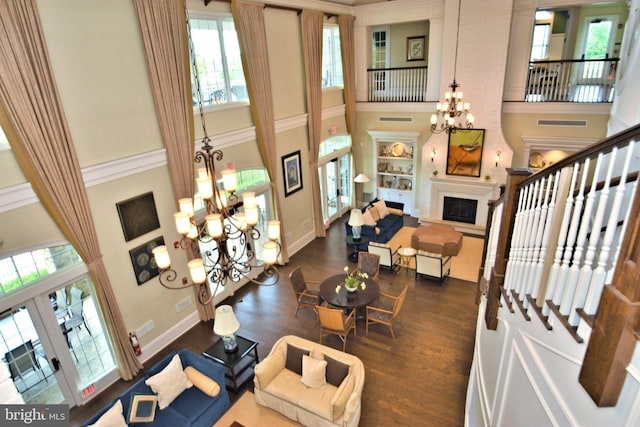 living room featuring a high ceiling, dark hardwood / wood-style flooring, an inviting chandelier, and french doors