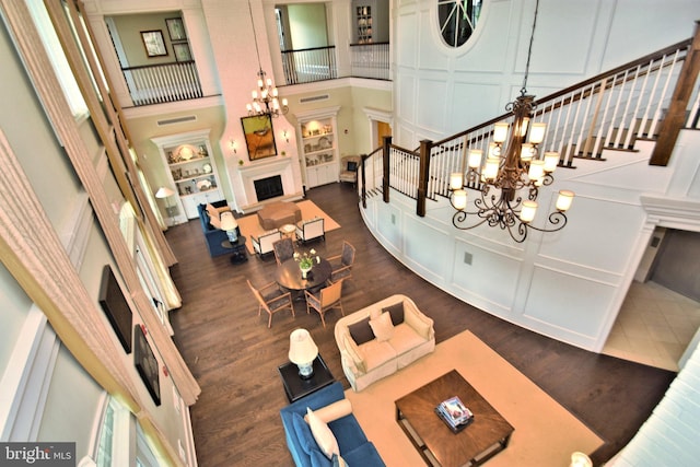 living room with a towering ceiling, dark wood-type flooring, and a chandelier