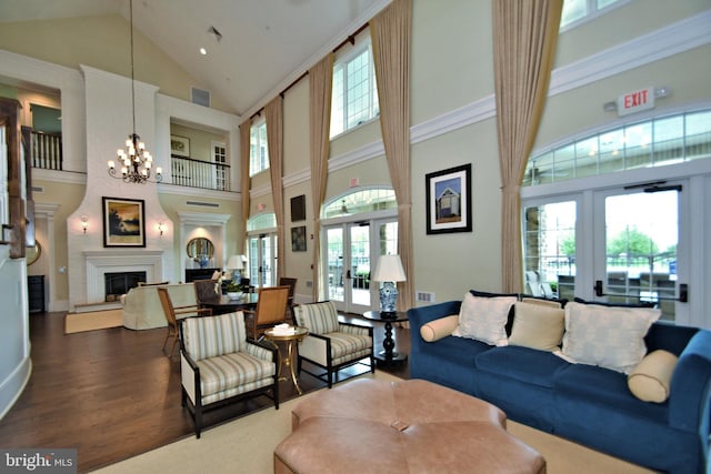 living room with french doors, a chandelier, high vaulted ceiling, dark hardwood / wood-style flooring, and a fireplace