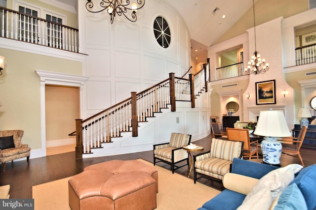 living room with an inviting chandelier, dark hardwood / wood-style floors, and high vaulted ceiling