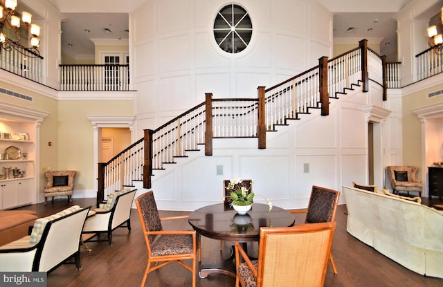 dining space with built in features, dark wood-type flooring, and ornamental molding