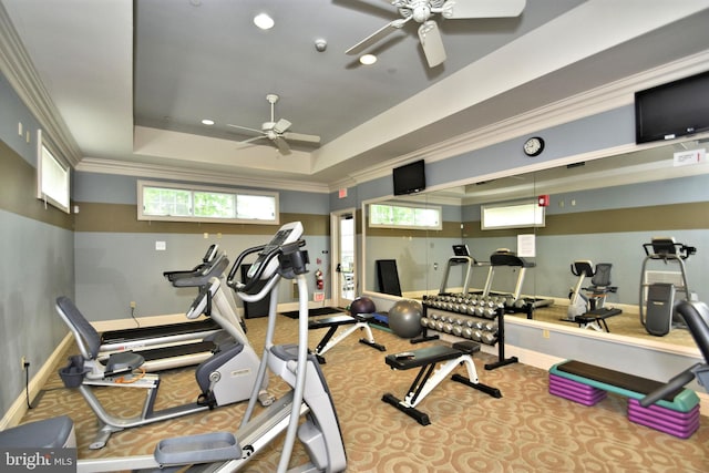 exercise room with crown molding, a raised ceiling, and ceiling fan