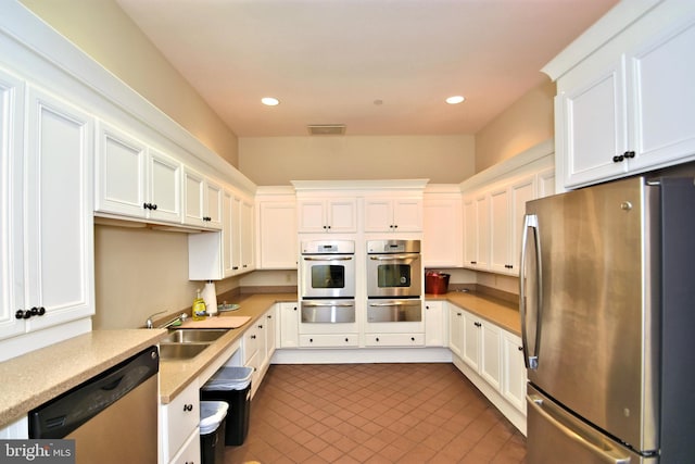 kitchen featuring sink, white cabinets, and appliances with stainless steel finishes