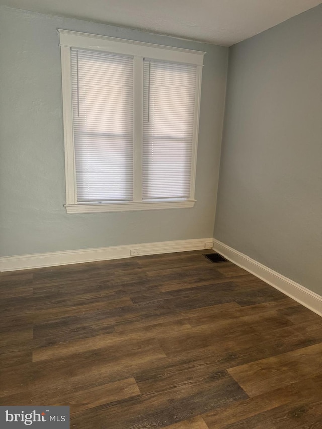 empty room with dark hardwood / wood-style floors