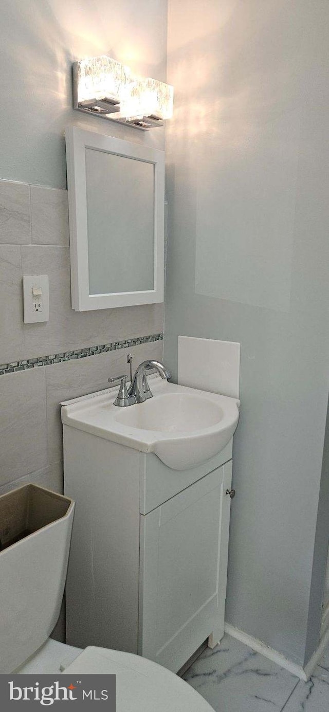 bathroom featuring vanity and tile walls