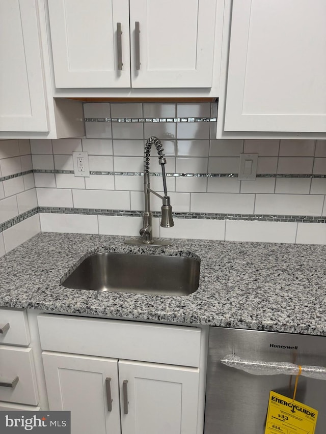 kitchen featuring white cabinetry, dishwasher, sink, and tasteful backsplash