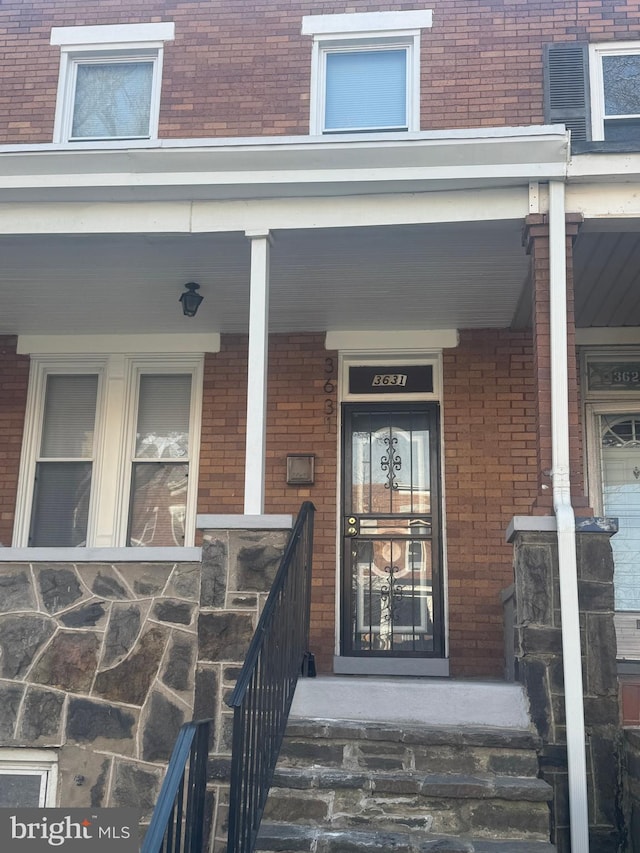 view of exterior entry featuring covered porch