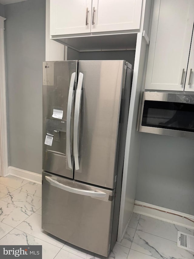 kitchen with appliances with stainless steel finishes and white cabinets