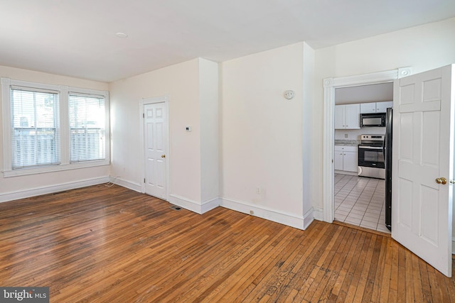 spare room featuring dark wood-type flooring