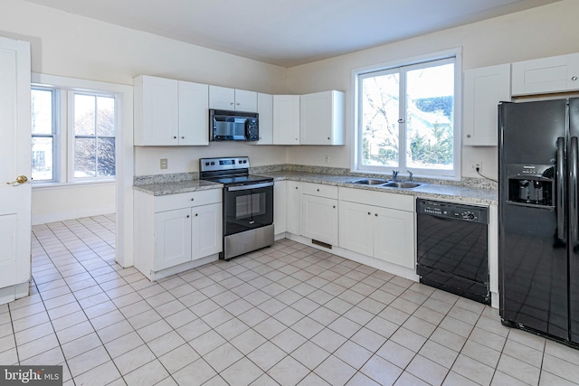 kitchen featuring white cabinetry, sink, light tile patterned flooring, and black appliances