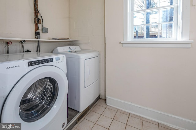 clothes washing area featuring separate washer and dryer and light tile patterned floors