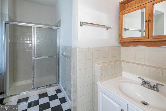 bathroom featuring vanity, tile walls, and a shower with shower door