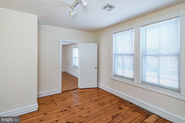 unfurnished room featuring rail lighting and light wood-type flooring