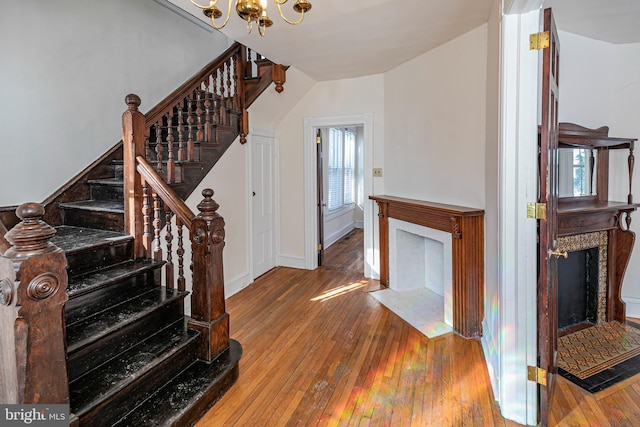 stairs with an inviting chandelier and wood-type flooring