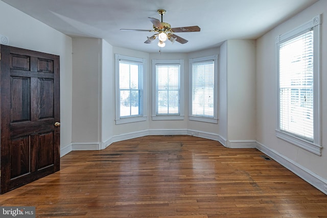 interior space with plenty of natural light, dark hardwood / wood-style floors, and ceiling fan