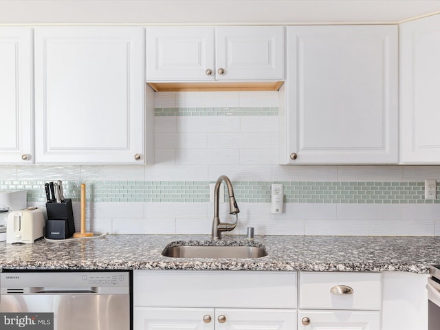 kitchen featuring white cabinetry, sink, decorative backsplash, and stainless steel dishwasher