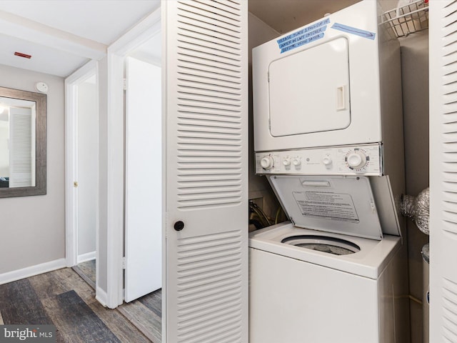 washroom with stacked washer and dryer and dark hardwood / wood-style floors