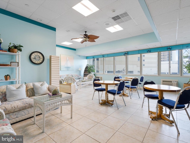 tiled living room with a paneled ceiling and ceiling fan