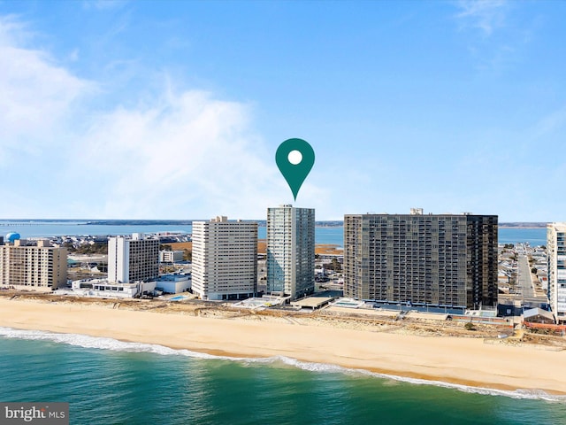 birds eye view of property featuring a water view and a beach view