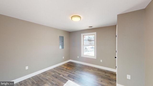 unfurnished room featuring dark hardwood / wood-style flooring and electric panel