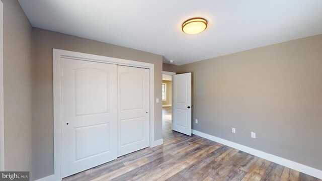 unfurnished bedroom with light hardwood / wood-style floors and a closet