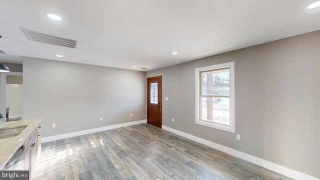 unfurnished living room with sink and light hardwood / wood-style floors