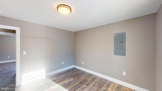 unfurnished room with hardwood / wood-style flooring and electric panel