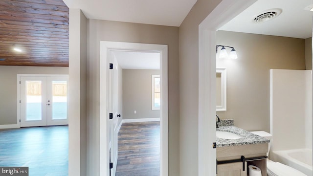 hallway with sink, wood-type flooring, and french doors