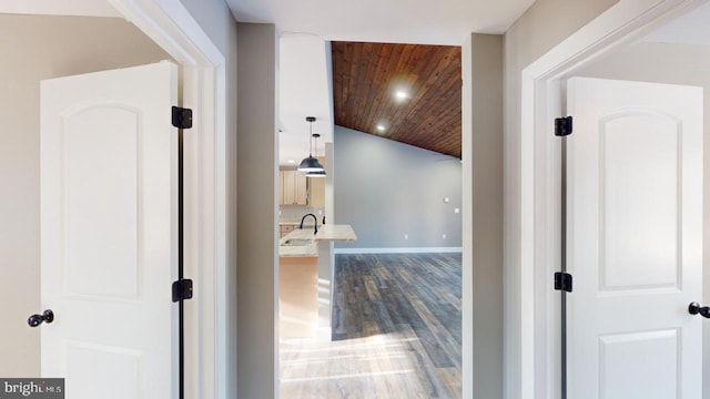 corridor with wood-type flooring, lofted ceiling, and wood ceiling