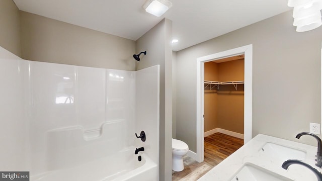 full bathroom with shower / bathtub combination, wood-type flooring, toilet, and vanity