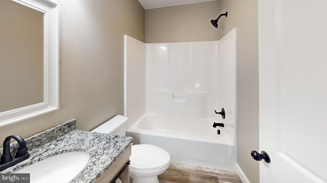 full bathroom with hardwood / wood-style flooring,  shower combination, vanity, and toilet