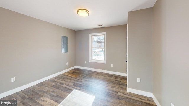 unfurnished room featuring dark hardwood / wood-style flooring and electric panel