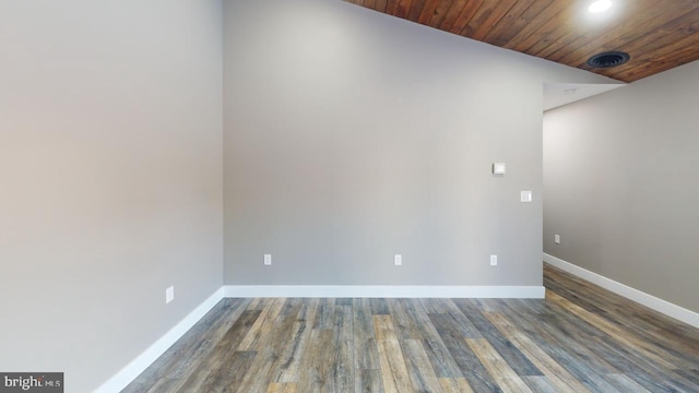 spare room with lofted ceiling, dark hardwood / wood-style flooring, and wooden ceiling