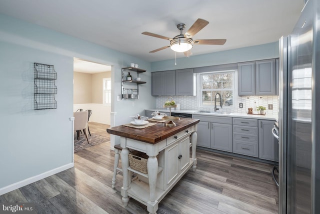 kitchen featuring stainless steel fridge, sink, hardwood / wood-style floors, and backsplash