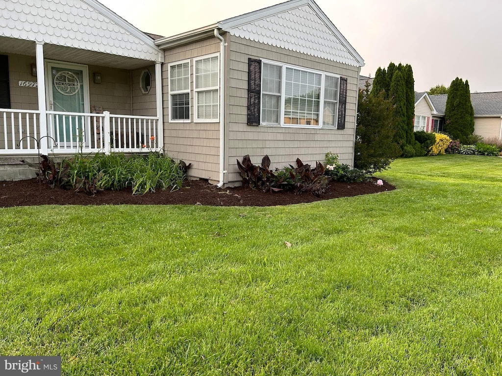 view of home's exterior with a yard and covered porch