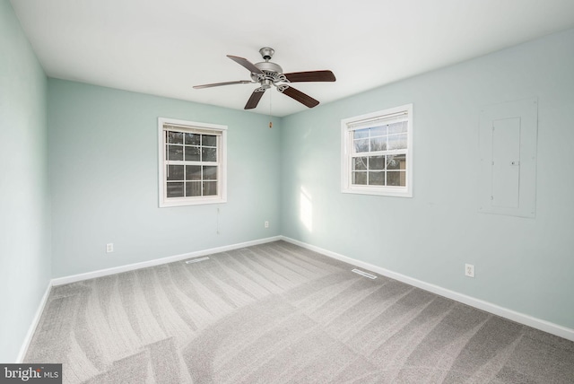 carpeted spare room featuring electric panel and ceiling fan