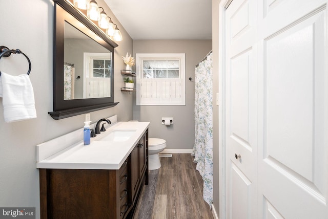 bathroom with hardwood / wood-style flooring, vanity, and toilet